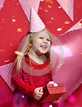 Adorable pretty girl with pink balloons and red present gift and birthday cap