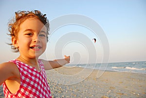 Three years old girl playing on the beach
