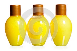 Three yellow bottles of cosmetics