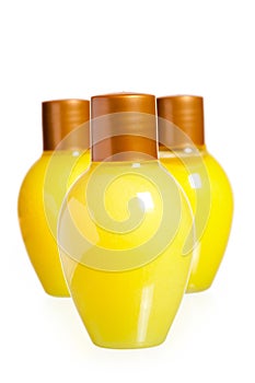 Three yellow bottles of cosmetics