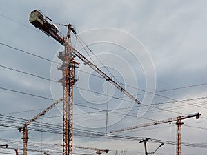 Three yellow construction crane against blue sky