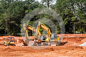 Three Yellow Construction Machines