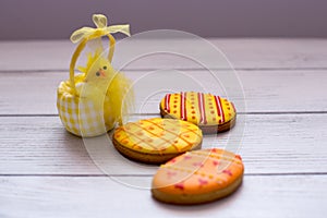 Three yellow easter cookies with a chik on the left photo