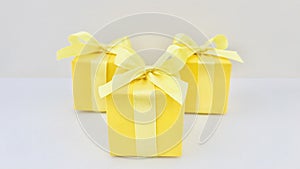 Three Yellow gift boxes on white and creamy background.