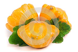 Three yellow pattypan squash with leaf isolated on white background