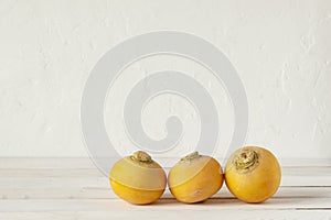 Three yellow raw organic turnips on the white background