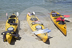 Three yellow sea tandem kayak on beach