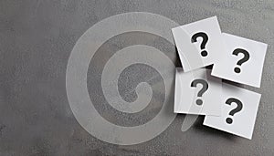 Paper notes with question marks on Grey background, flat lay. Space for text