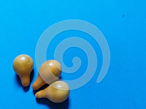 Three yellow tomatoes and blue background