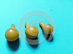 Three yellow tomatoes and blue background