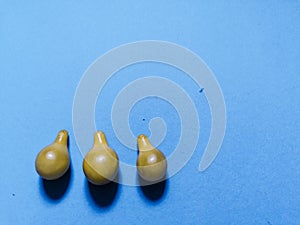 Three yellow tomatoes and blue background