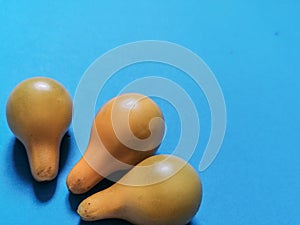Three yellow tomatoes and blue background