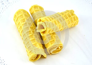 three yellow waffles on a white napkin