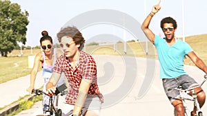 Three young adults having fun cycling and taking selfies, graded