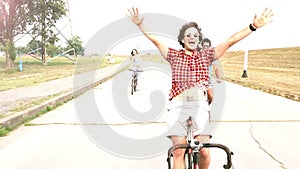 Three young adults having fun cycling on their bike, graded