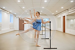 Three young ballerinas rehearsing at the barre