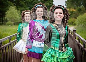 Three young beautiful girls in irish dance dress posing outdoor