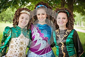 Three young beautiful girls in irish dance dress posing outdoor