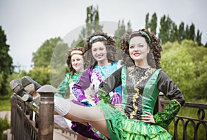 Three young beautiful girls in irish dance dress posing outdoor