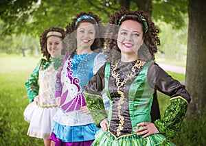 Three young beautiful girls in irish dance dress posing outdoor