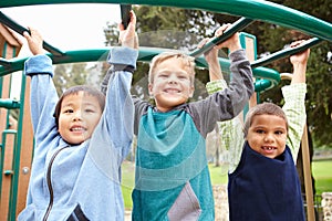 Three Young Boys On Climbing Frame In Playground