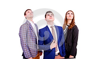 Three young business people looking up