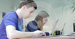 Three Young Business People Using Computer in the Office. Two Decorator`s Colleagues Working Together on an Innovative