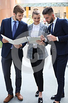 Three young businessmen standing discussing business at an office meeting