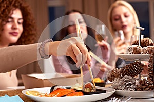 Three young cheerful intercultural women with alcoholic drinks standing in front of camera while enjoying home party in