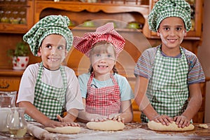 Three young children make a mess in the kitchen