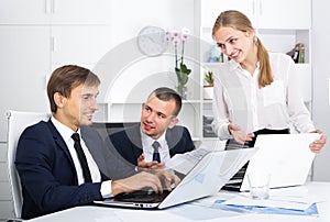 Three young coworkers different sexes working in company office