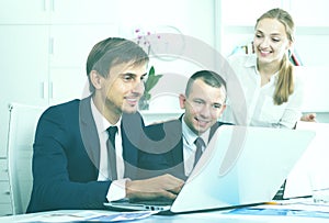 Three young coworkers working in company office