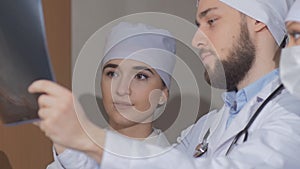 Three young doctors looking at spine x-ray. Slow motion