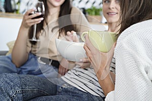 Three young females friends chatting at home