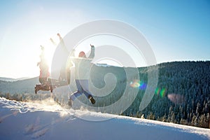 Three young friends jumping and having fun on the snowy mountain