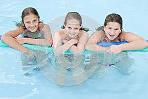 Three young girl friends in swimming pool