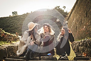 Three young girls sitting on the stairs.