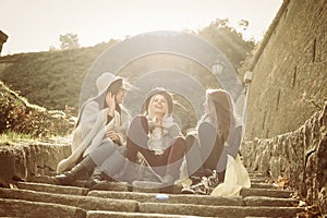 Three young girls sitting on the stairs.