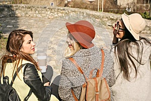 Three young girls sitting on the stairs at the public park.