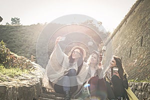 Three young girls sitting on the stairs at the public park.