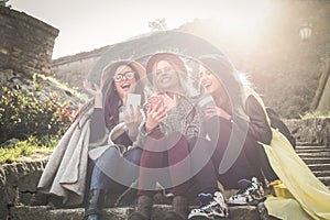 Three young girls sitting on the stairs at the public park.