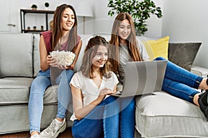 Three young hispanic woman smiling happy watching film using laptop at home
