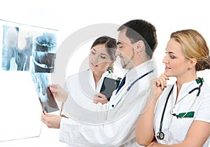 Three young medical workers examining x-rays