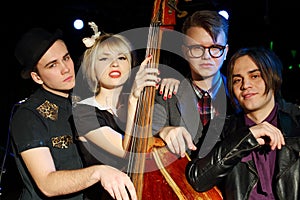 Three young men and beautiful woman with contrabass photo