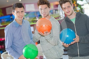Three young men with bowling ball