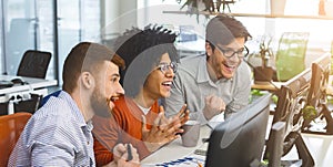 Three young men enjoying good coding job on computer