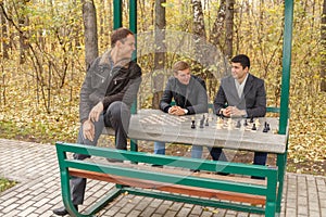Three young men sitting in gazebo for game of photo