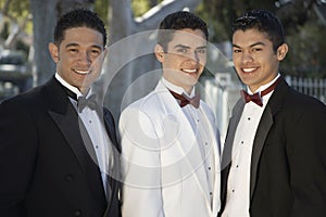 Three Young Men In Tuxedos Standing Together at Quinceanera