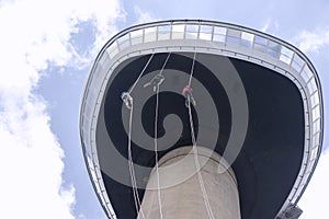 Three young People abseiling down the Euromast tower in Rotterdam