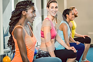 Three young people holding kettlebells during functional trainin photo